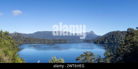 Majestätischer Blick auf einen riesigen klaren blauen See, der den Wald, der ihn umgibt, und die Bergkette in der Ferne, in Lago Espejo, Argenti, reflektiert Stockfoto