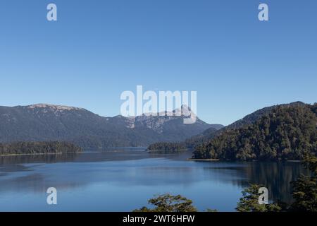 Majestätischer Blick auf einen riesigen klaren blauen See, der den Wald, der ihn umgibt, und die Bergkette in der Ferne, in Lago Espejo, Argenti, reflektiert Stockfoto