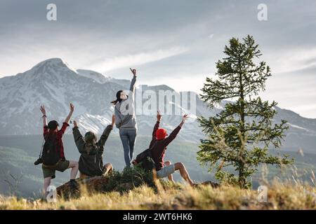 Eine Gruppe fröhlicher junger Wanderer hat Spaß in den Bergen bei Sonnenuntergang Stockfoto