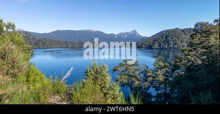 Majestätischer Blick auf einen riesigen klaren blauen See, der den Wald, der ihn umgibt, und die Bergkette in der Ferne, in Lago Espejo, Argenti, reflektiert Stockfoto