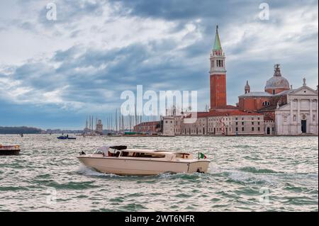 Wassertaxi vor der Insel San Giorgio Maggiore im Hintergrund in der Lagune von Venedig in Veneto, Italien Stockfoto