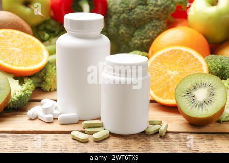 Nahrungsergänzungsmittel. Plastikflaschen, Pillen und Lebensmittel auf Holztisch Stockfoto