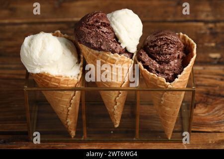 Leckere Eislöffel in Waffelkegeln auf Holztisch, Nahaufnahme Stockfoto