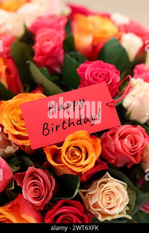 Blumenstrauß mit schönen Rosen mit Happy Birthday Karte, Nahaufnahme Stockfoto