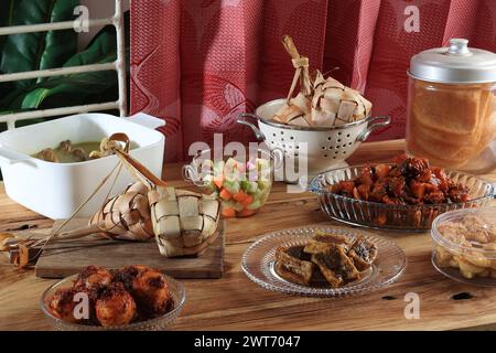 Ketupat Lebaran und verschiedene Beilagen auf dem Tisch. Menü EID al Fitr Stockfoto