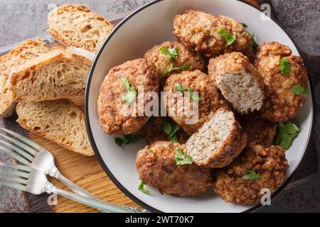 Gebratene Buchweizenfleischbällchen Hrechanyky aus Hackfleisch und gekochtem Buchweizenbrei mit Zwiebeln, Gewürzen in einem Teller auf dem Tisch. Horizontal t Stockfoto