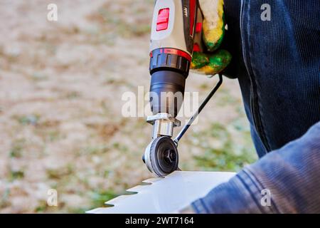 Schneidausrüstung für Bleche, Adapter für Bohrplattenschneider, Nahaufnahme des Elektrowerkzeugs zum Schneiden von Dacheisen von außen. Stockfoto