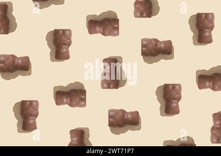 Trendige Musterkomposition mit Schokoladen-Teddybären auf Pastellcremehintergrund. Kreatives Konzept für süße Speisen. Leckere Schokoladen-Teddybären-Idee. Stockfoto