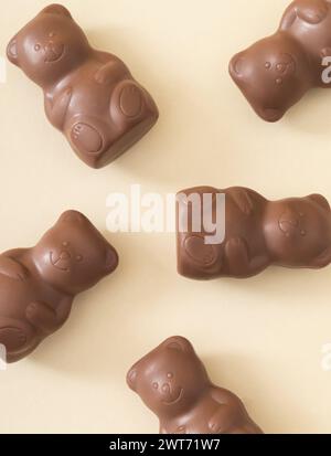 Trendige Musterkomposition mit Schokoladen-Teddybären auf Pastellcremehintergrund. Kreatives Konzept für süße Speisen. Leckere Schokoladen-Teddybären-Idee. Stockfoto