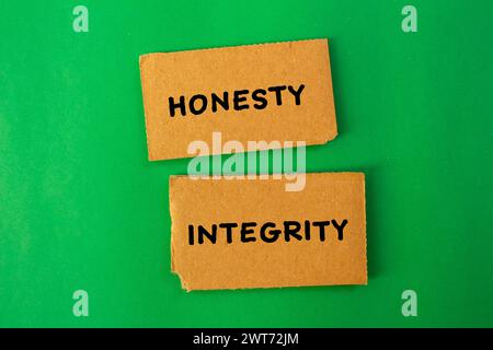 Ehrlichkeit und Integrität auf gerissenen Papierstücken mit grünem Hintergrund. Konzeptsymbol. Kopierbereich. Stockfoto
