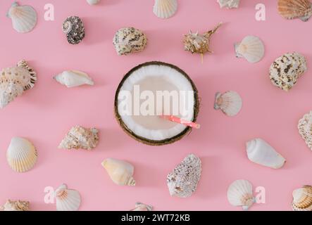 Tropisches Strandkonzept aus Kokosnussfrüchten und Muscheln auf pastellrosa Hintergrund. Kreative Sommerkomposition. Minimales Layout. Stockfoto