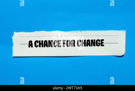 Eine Chance, Wörter zu ändern, geschrieben auf zerrissenem Papier mit blauem Hintergrund. Konzeptsymbol. Kopierbereich. Stockfoto