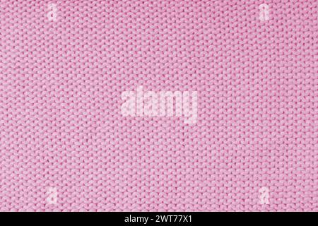 Nahaufnahme des Hintergrunds des gestrickten Wollgewebes aus Viskosegarn, rosa Farbe Wollstrick Textur. Pullover mit gestricktem Jersey-Hintergrund. Material Stockfoto