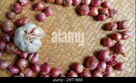 Foto von Gewürzen in Form von Schalotten, Knoblauch, Chilis und Eiern, die in einem gewebten Bambus angeordnet sind Stockfoto