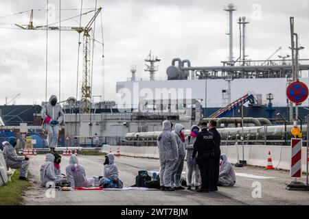 16. März 2024, Schleswig-Holstein, Brunsbüttel: Mitglieder der Umweltgruppe Ende Gelände blockieren die Zufahrtsstraße zum schwimmenden LNG-Terminal. Sie fordern eine sofortige Einstellung der Einfuhren von Flüssigerdgas. Foto: Frank Molter/dpa Credit: dpa Picture Alliance/Alamy Live News Stockfoto