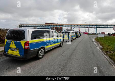 16. März 2024, Schleswig-Holstein, Brunsbüttel: Polizeifahrzeuge parken am Elbhafen. Mitglieder der Umweltgruppe Ende Gelände blockieren den Zugang zum schwimmenden LNG-Terminal. Sie fordern eine sofortige Einstellung der Einfuhren von Flüssigerdgas. Foto: Frank Molter/dpa Credit: dpa Picture Alliance/Alamy Live News Stockfoto