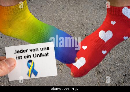 16. März 2024: Symbolisches Bild des World Down Syndrome Day, zwei Füße mit verschiedenfarbigen Socken und eine Hand mit einem Stück Papier mit der Inschrift: Jeder von uns ist einzigartig. PHOTOMONTAGE *** Symbolbild Welt Down Syndrom Tag, zwei Füße mit verschiedenen farbigen Socken und eine Hand mit einem Stück Papier mit der Aufschrift: Jeder von uns ist ein Unikat. FOTOMONTAGE Stockfoto