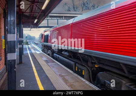 British Rail Railways Network Rail Vorortbahn für Personennahverkehr West Midlands England UK Güterzug durch den Bahnhof. Stockfoto