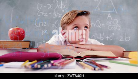 Bild von Mathe-Formeln über nachdenklichem kaukasienlernen in der Schule Stockfoto