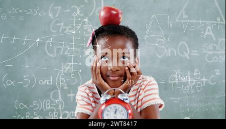 Bild von Mathe-Formeln über nachdenklichem afrikanischem Americna-Mädchen mit Apfel über Tafel Stockfoto