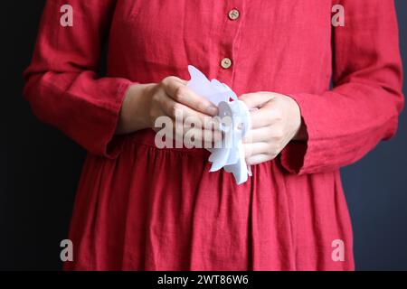 Halloween-Vorbereitungen. Junge Frau mit festlicher Girlande auf schwarzem Hintergrund mit Kopierraum. Halloween-Dekorationen aus nächster Nähe Foto. Stockfoto