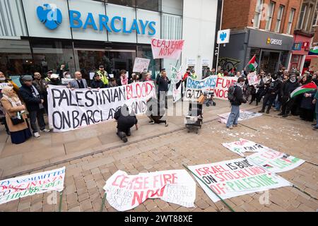 Manchester, Großbritannien. März 2024. Palästinensische Gaza-Proteste im Stadtzentrum von Manchester, beginnend in den Piccadilly Gardens. Die Demonstranten marschierten in der 23. Woche in Folge durch das Stadtzentrum, überwacht von der Polizei. Demonstranten hielten an der Barclays Bank an, die eine Meldung über eine vorübergehende Schließung an ihren Türen hatte. Die Demonstranten skandierten, dass die Barclays Bank in Bezug auf den aktuellen Konflikt „Blut an den Händen“ habe, und zeichneten Botschaften auf dem Bürgersteig. Ein Gebäude an der King Street wurde auch wegen seiner Verbindungen zur AXA Insurance herausgestellt. Der marsch hielt Straßenbahnen, Käufer und Verkehr auf, während Tausende friedlich marschierten. M Stockfoto