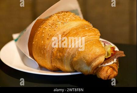 Bild eines köstlichen Croissants auf einem Teller mit Schinken und Zwiebeln Stockfoto