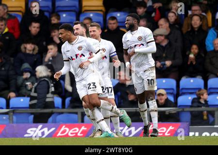 Kyle Jameson (links) von Newport County feiert, nachdem er ihr zweites Tor mit Scot Bennett (Mitte) und Offrande Zanzala (rechts) während des Spiels der Sky Bet League Two im Cherry Red Records Stadium in London erzielt hat. Bilddatum: Samstag, 16. März 2024. Stockfoto