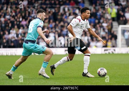 Korey Smith von Derby County (rechts) geht an Bolton Wanderers’ Aaron Collins während des Spiels der Sky Bet League One im Pride Park in Derby vorbei. Bilddatum: Samstag, 16. März 2024. Stockfoto