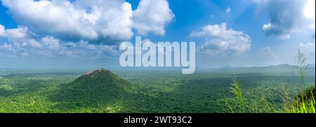 Ein nachmittags Panoramablick vom Gipfel des Sigiriya Rock, mit Blick auf einen riesigen grünen Wald mit weit entfernten Bergketten unter blauem Himmel. Stockfoto