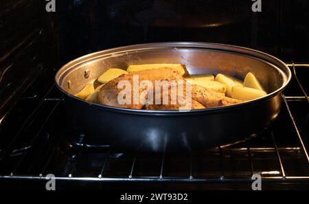 Hühnerfleisch mit Kartoffeln wird im Ofen gebacken Stockfoto