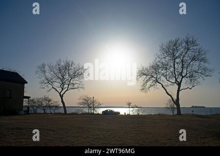 Die untergehende Sonne akzentuiert und Silhouetten der Bäume an der Sandy Hook Bay an einem sonnigen Tag im Spätwinter -33 Stockfoto