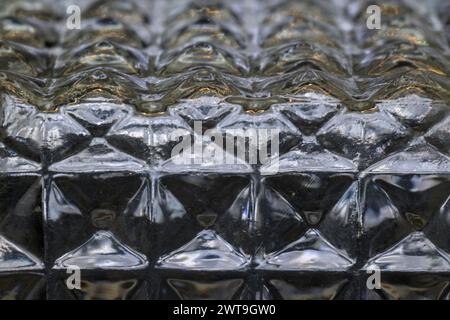 Detail des Randes der Glasflasche, geschnitzte quadratische Sechsecke, horizontal beleuchtet Stockfoto