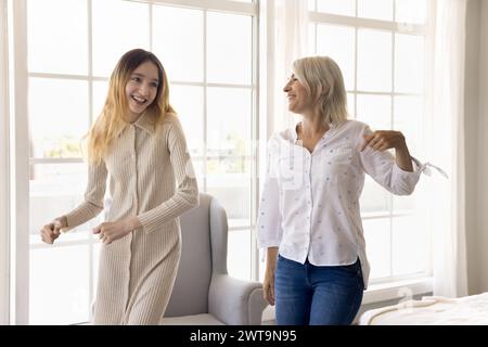 Fröhliche Mutter und Tochter tanzen zu Hause zusammen Stockfoto
