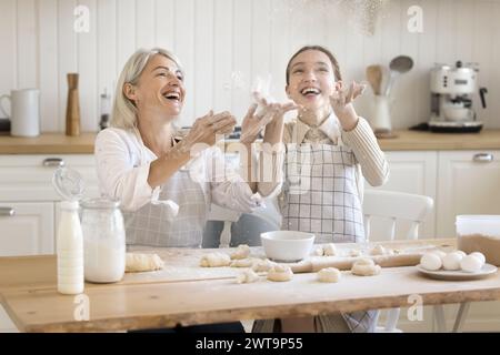 Teenager-Mädchen und Mutter haben Spaß, Mehl zu werfen, zusammen zu kochen Stockfoto