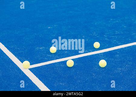 Ein Paddeltennisplatz mit einer blauen Linie und fünf Tennisbälle auf dem Platz Stockfoto