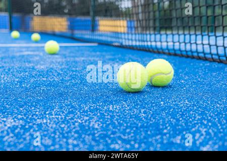 Fünf Paddeltennisbälle stehen auf einem blauen Platz. Die Kugeln sind gelb und liegen auf dem Boden Stockfoto