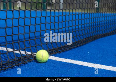 Ein Paddletennis-Ball sitzt auf einem blauen Platz mit einem Netz- und Racketsportkonzept Stockfoto