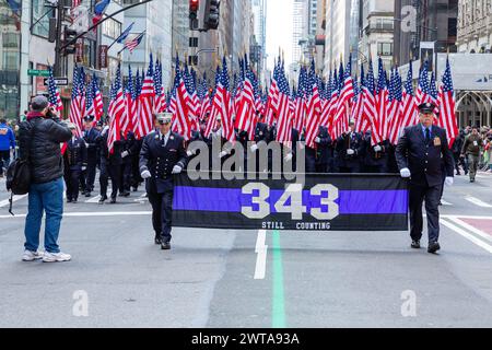 New York, NY, USA. März 2024. Irisch-amerikanische Kontingente starteten von der New Yorker St. Patrick's Day Parade zu den Klängen zahlreicher Pfeifenbänder und bejubelt von den Zuschauern, von denen viele in Grün bedeckt sind. Die 343 Honor Company, mit Fahnenträger, die eine Flagge für jeden der 343 Feuerwehrleute tragen, die am 1. September 2001 in den Twin Towers starben. Quelle: Ed Lefkowicz/Alamy Live News Stockfoto