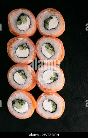 Leichtes Lachskäse Sushi philadelphia auf schwarzem Schreibtisch. Draufsicht Stockfoto