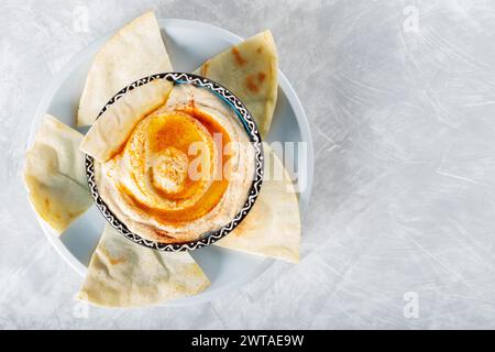 Kichererbsen Hummus Schüssel und Pita auf grauem Betonhintergrund, Kopierraum, Draufsicht Stockfoto