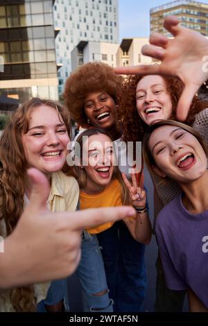 Selfie von multirassischen Freundinnen, die in der Stadt Gesten mit Fingern machen. Stockfoto