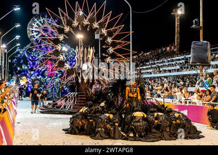 Ein Karnevalsschwimmer und eine Gruppe junger Leute tanzen im Corsodromo im jährlichen Karneval del Pais, Gualeguaychu, Provinz Entre Rios, Argentinien. Stockfoto