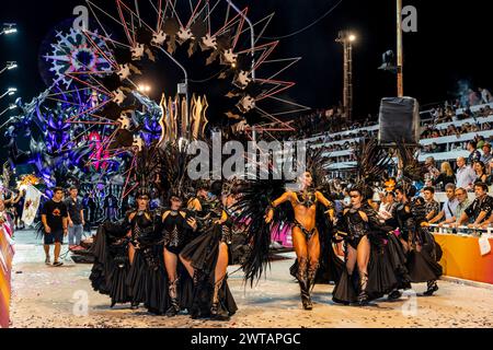 Ein Karnevalsschwimmer und eine Gruppe junger Leute tanzen im Corsodromo im jährlichen Karneval del Pais, Gualeguaychu, Provinz Entre Rios, Argentinien. Stockfoto