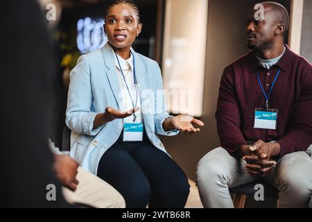 Zwei engagierte Fachleute führen ein fokussiertes Gespräch, während sie zusammen auf einer Business expo sitzen. Geschäftsleute zeigen Zusammenarbeit und Networking Stockfoto