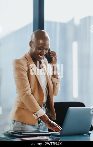 Geschäftsfrau steht hinter ihrem Schreibtisch in einem Büro, spricht auf dem Smartphone und spricht über ein Projekt. Professioneller und erfolgreicher Unternehmer, der t Stockfoto