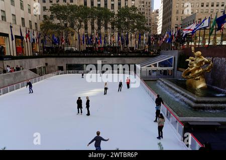 Besucher können Schlittschuhlaufen im Rockefeller Center bei der Prometheus-Statue, umgeben von Wolkenkratzern, Manhattan, Brooklyn, New York City, New York Stockfoto