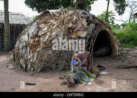 Zwergfrau der Baka oder BaAka mit ihrem Kind vor ihrer Hütte, Bayanga, Präfektur Sangha-Mbaere, Zentralafrikanische Republik Stockfoto