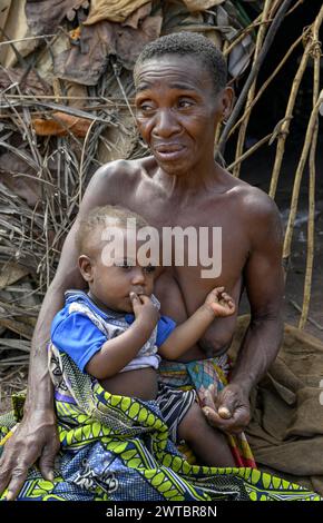 Zwergfrau der Baka oder BaAka mit ihrem Kind vor ihrer Hütte, Bayanga, Präfektur Sangha-Mbaere, Zentralafrikanische Republik Stockfoto