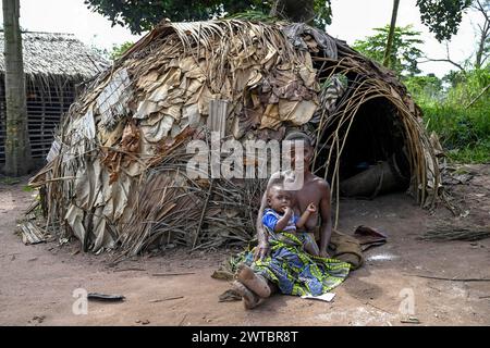 Zwergfrau der Baka oder BaAka mit ihrem Kind vor ihrer Hütte, Bayanga, Präfektur Sangha-Mbaere, Zentralafrikanische Republik Stockfoto